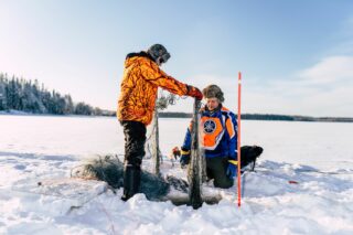 Miehet tarkistavat kalaverkkoja Iso-Ruuhijärven jäällä