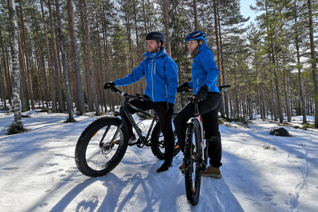 Maastopyöräilijät talvisessa metsässä